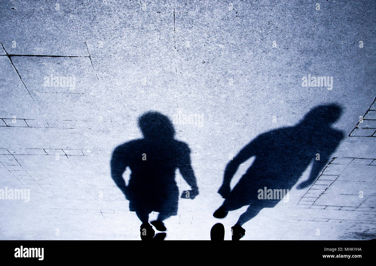 Verschwommene Schatten und Silhouette von Menschen zu Fuß auf der Straße Bürgersteig in der Nacht Stockfoto