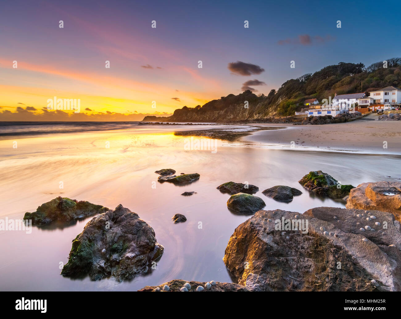 Pink und Gelb Himmel über Rock Pools am Strand, Steephill Cove. Stockfoto