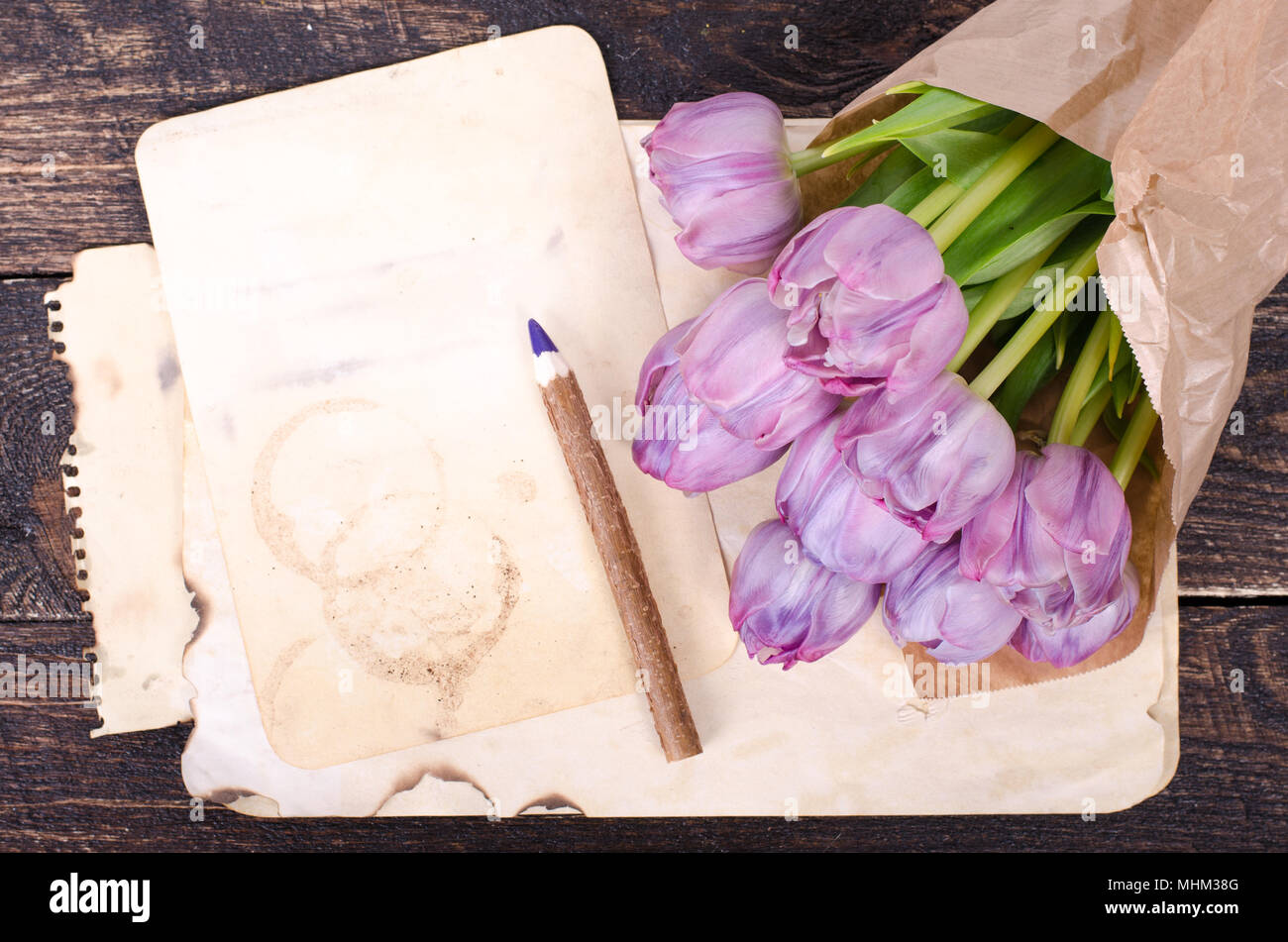 Violett Tulpen und vintage Papier, Bleistift auf einem hölzernen Hintergrund. Freier Platz für Ihren Text. Stockfoto