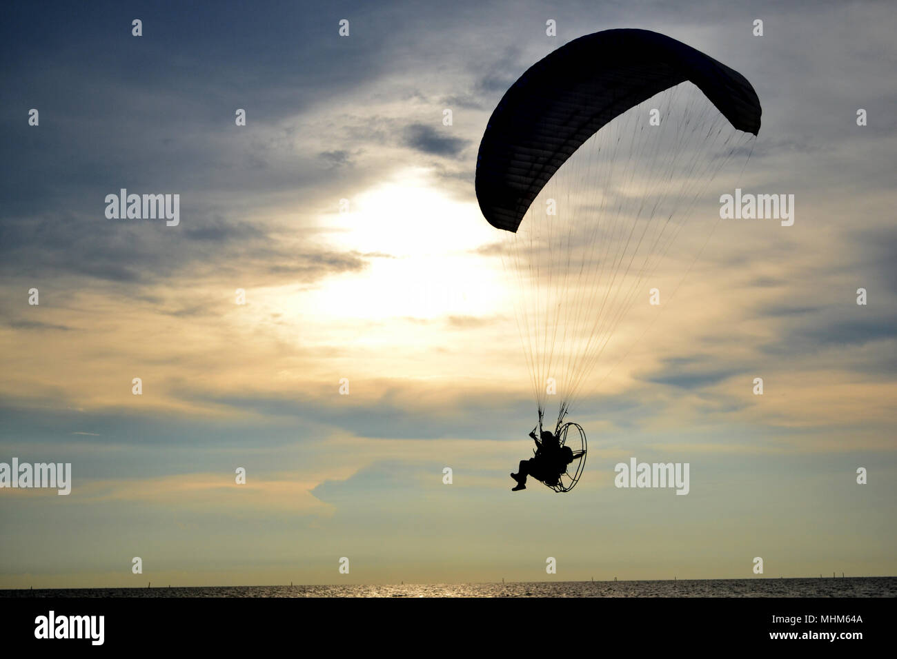 Silhouette einer Motorschirm über Meer und Sonnenuntergang Himmel Stockfoto