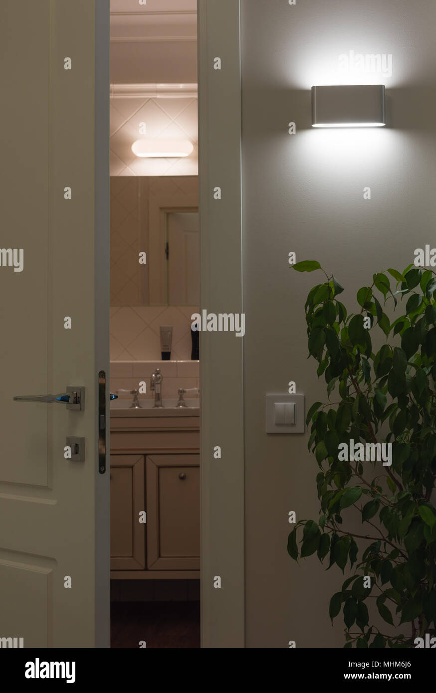 Wand LED-Lampen im Innenraum. Weiße Tür zum Bad zu öffnen. Vergleich von  Led- und Halogen Licht Stockfotografie - Alamy