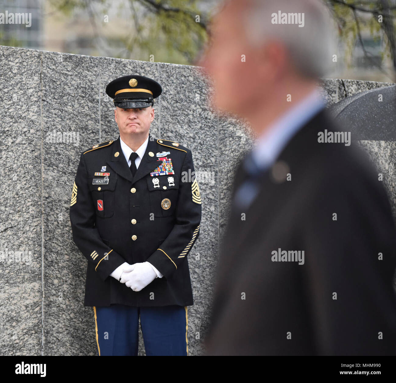 Little Rock, Arche: - Arkansas National Guard älterer Soldat Führer, Command Sergeant Major Steven Veazey hört als Arkansas Gouverneur Asa Hutchinson während einer Arkansas Abteilung der Veterans Affairs Kranzniederlegung Donnerstag, März 28, 2018 spricht, an der Vietnam Veterans' Denkmal auf dem Gelände des Arkansas State Capitol, die Zeremonie geehrt SGT Willie Pippins Sr. (Little Rock, AR) und SPC Glennon Marcussen (Monticello, AR). Beide Pippins" und marcussen Die Namen sind auch auf das Vietnam Memorial in Washington DC. (U.S. Army National Guard Stockfoto