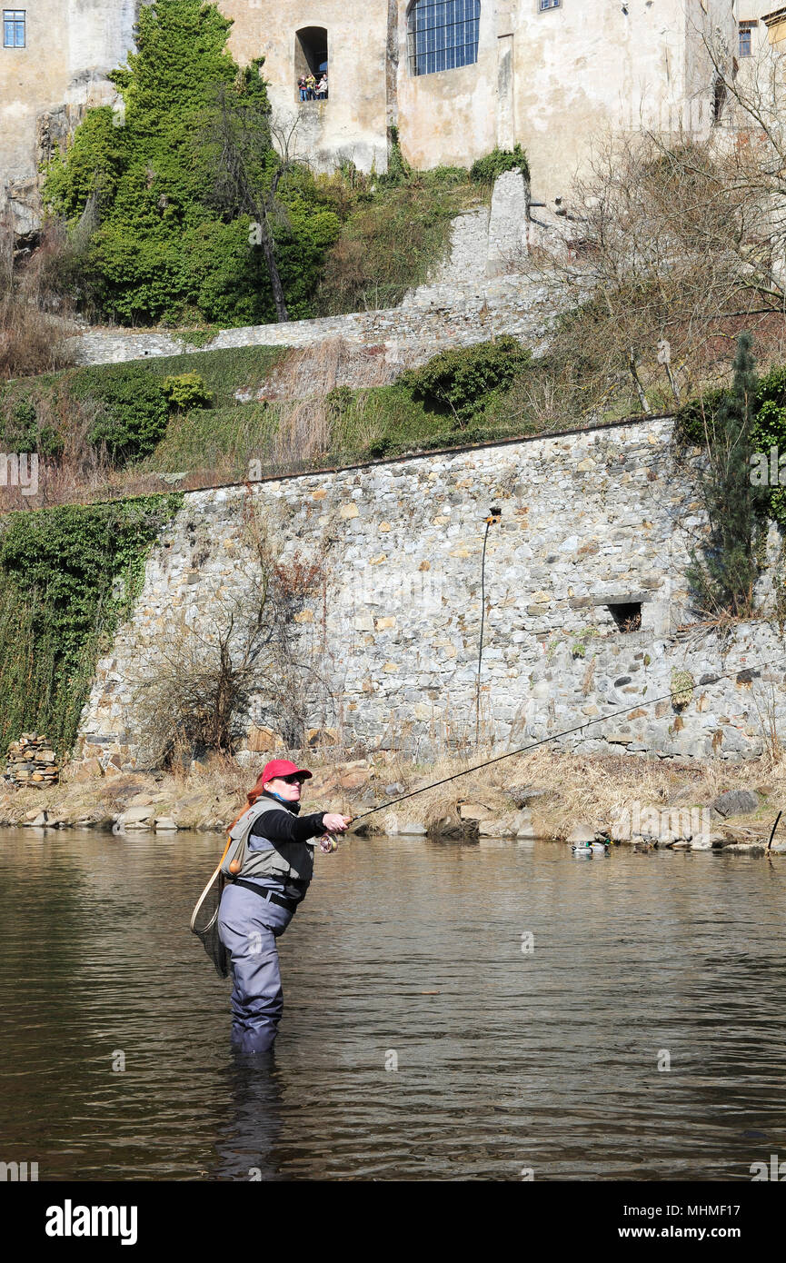 Eine Frau, die Fischerei in den Gewässern der Moldau unterhalb der Burg von Cesky Krumlov. Die Moldau ist der längste Fluss innerhalb der Tschechischen Republ Stockfoto