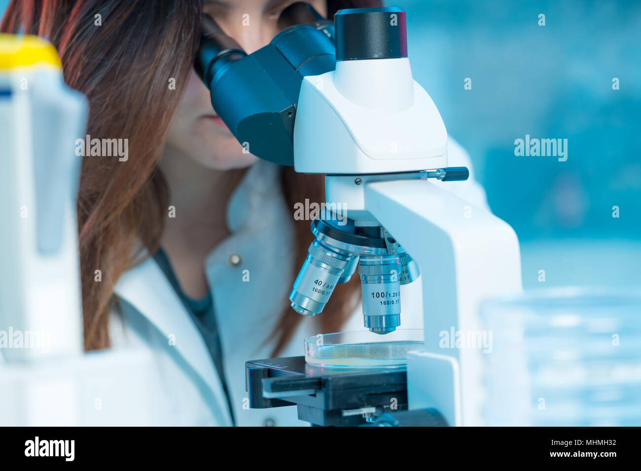 Junge Frau Techniker in einem wissenschaftlichen Labor mit Objektträger Stockfoto