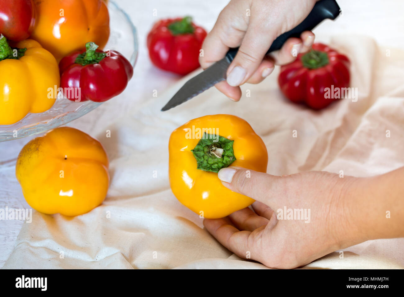 Frau mit Messer seeding Tomate Paprika. Stockfoto