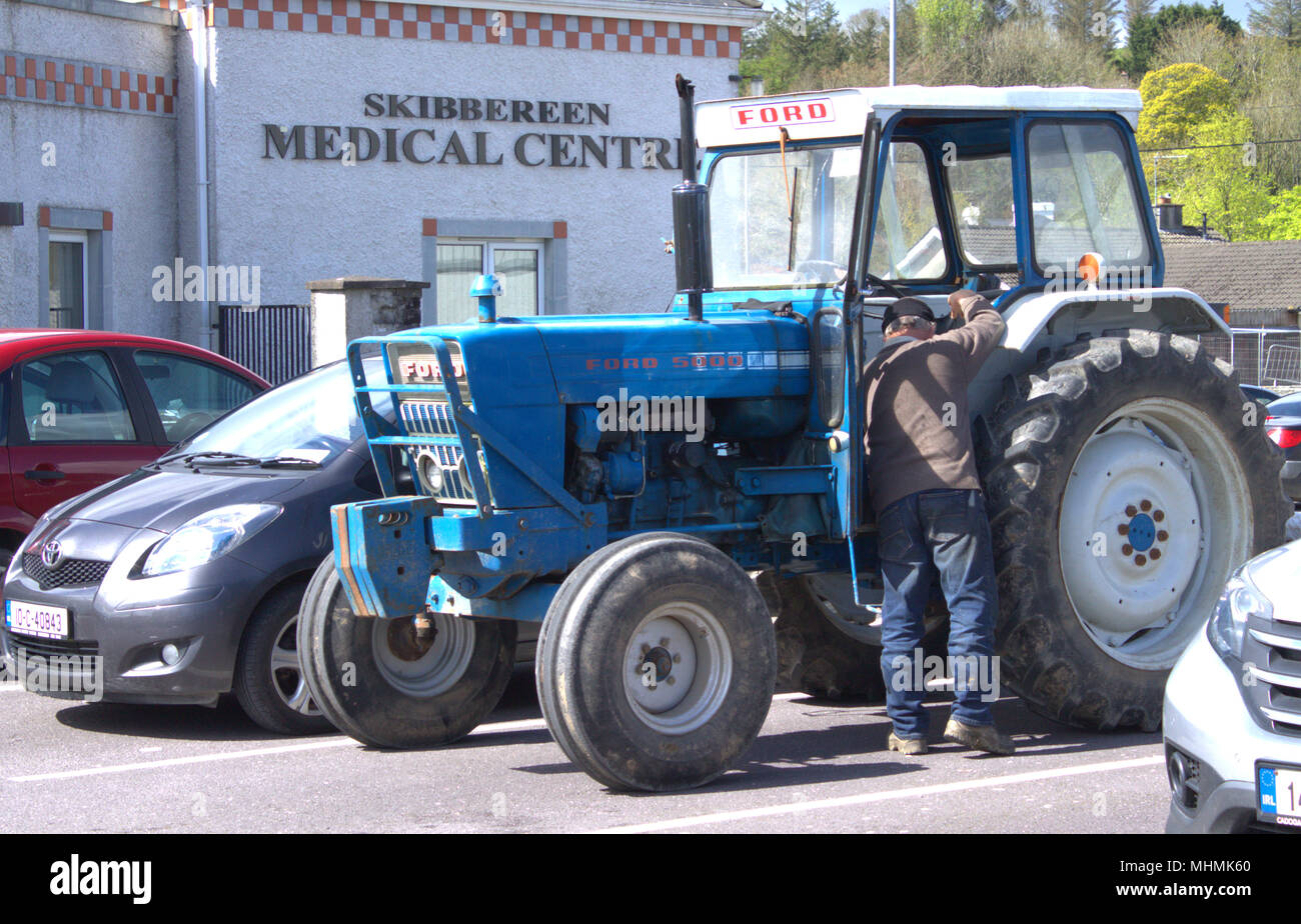 Das Leben im ländlichen Raum, ein Bauer besuche die Ärzte Chirurgie Fahren seines Ford 5000 Traktor, in Skibbereen, County Cork, Irland Stockfoto
