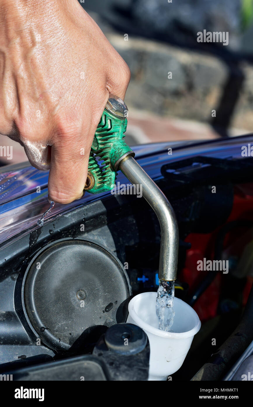 Nahaufnahme Eines Jungen Kaukasischen Mann Befullung Des Behalters Der Scheibenwaschanlage Flussigkeit Von Einem Auto Mit Wasser Aus Einem Gartenschlauch Stockfotografie Alamy