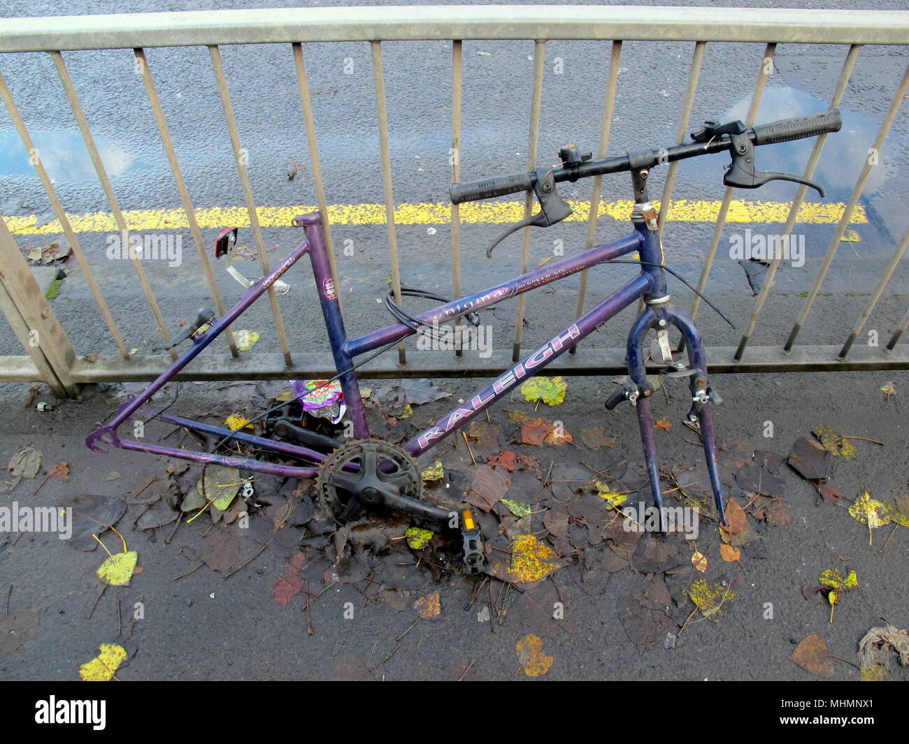 Das Raleigh Fahrrad Company Limited gebrochen gestohlen abgebrochenen Rad Räder stehlen Sattel stahlen Fahrrad angekettet Geländer gelbe Linie niemand copyspace Stockfoto