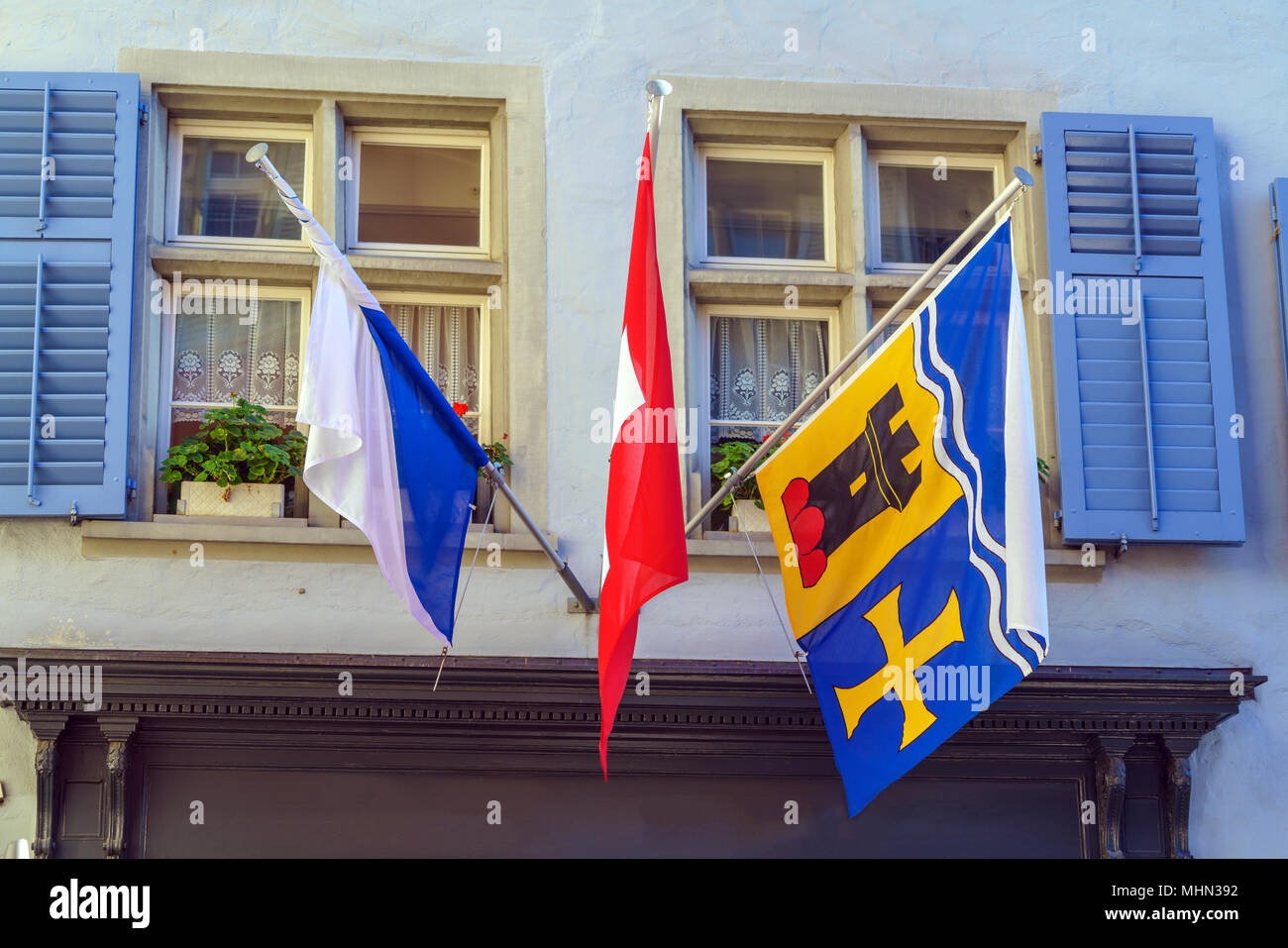 Flags, die mit einem lokalen Wappen der Kantone und Städte auf das Haus, Zürich, Schweiz Stockfoto
