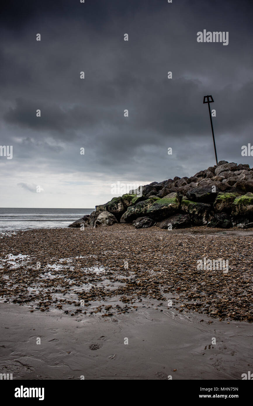 Dramatische Felsen und Wetter Highcliffe Strand in Dorset, UK Die Flut ist, enthüllt viele versteckte Details rund um den See die Abwehrkräfte. Stockfoto