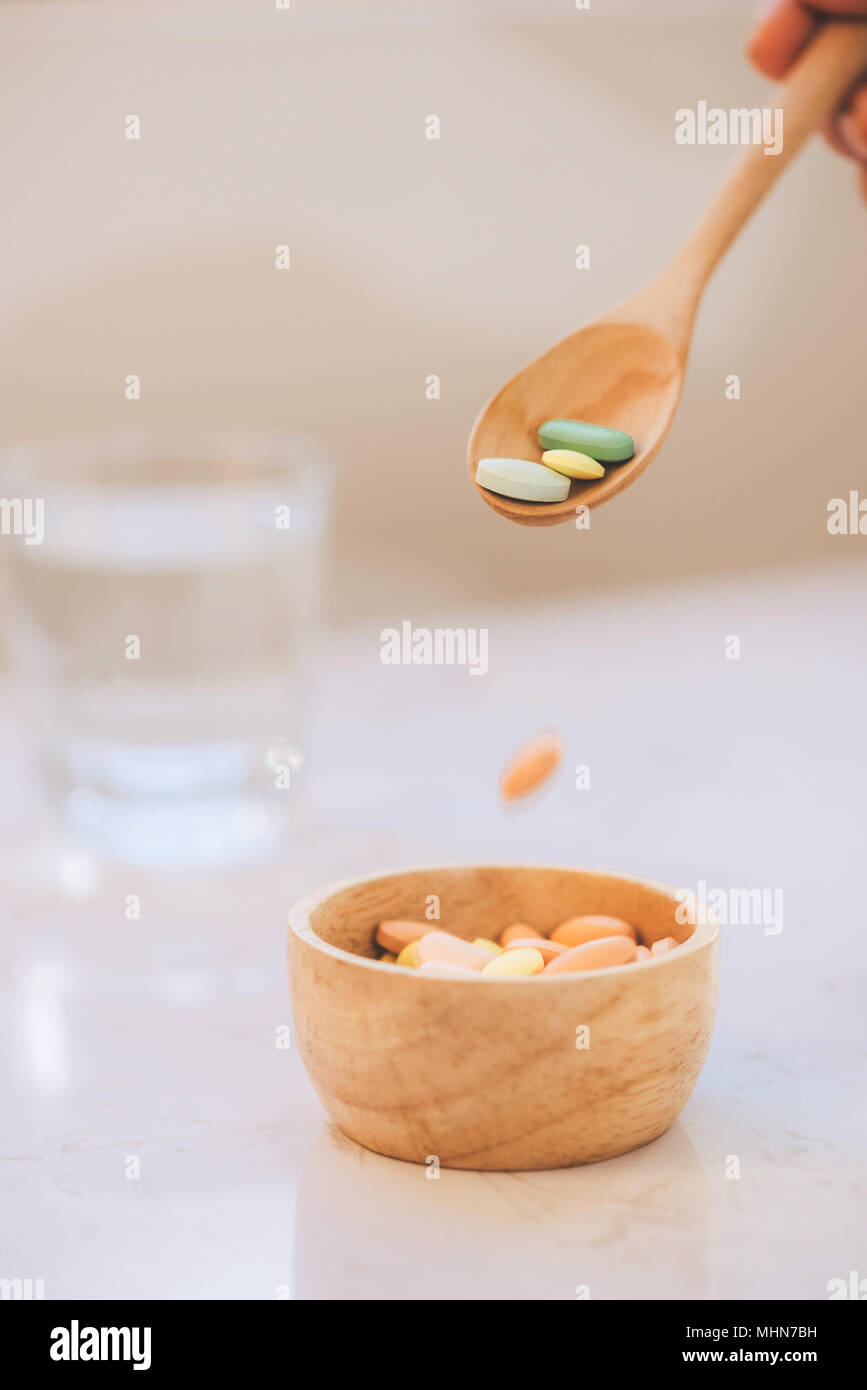 Verschiedene pharmazeutische Medizin Pillen, Tabletten und Kapseln auf hölzerne Schüssel Stockfoto