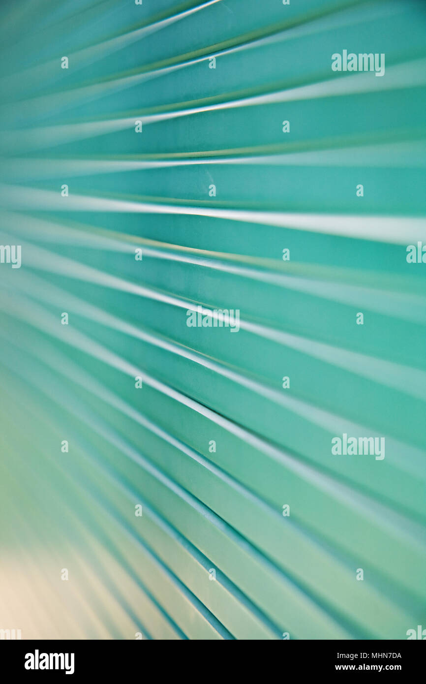 Makroaufnahme eines Stapels von grünen Glaspaneelen mit konvergierenden Linien und flache Tiefenschärfe. Stockfoto