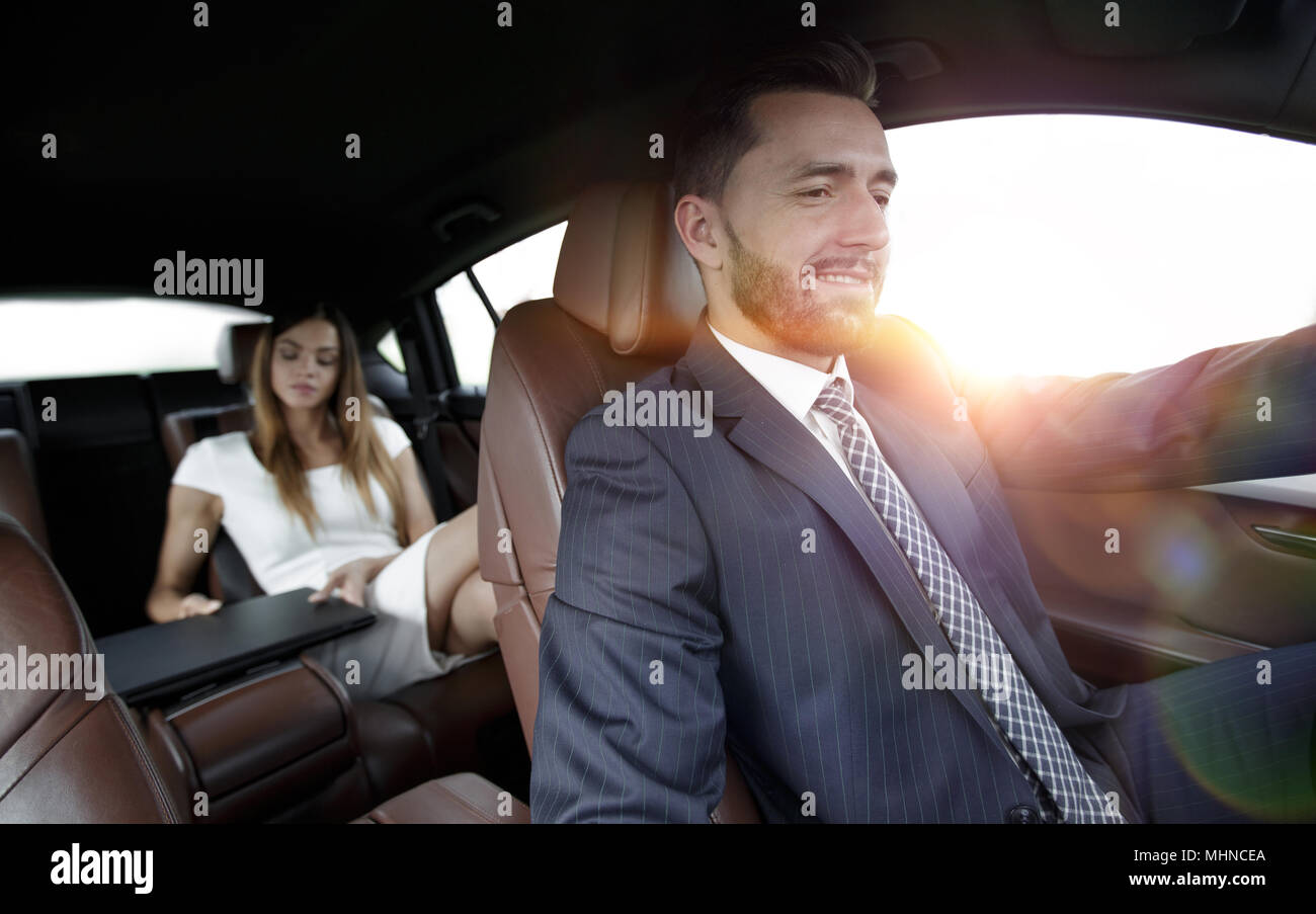 Unternehmer mit einem Computer im Auto gehen auf einer Geschäftsreise Stockfoto