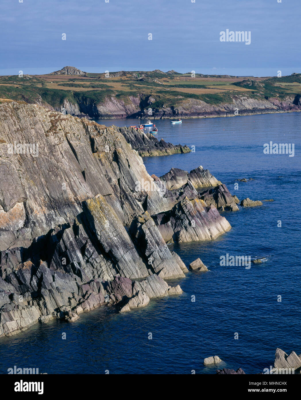Felsformationen NR ST DAVID'S Pembrokeshire mit angelegten Boote in See Stockfoto