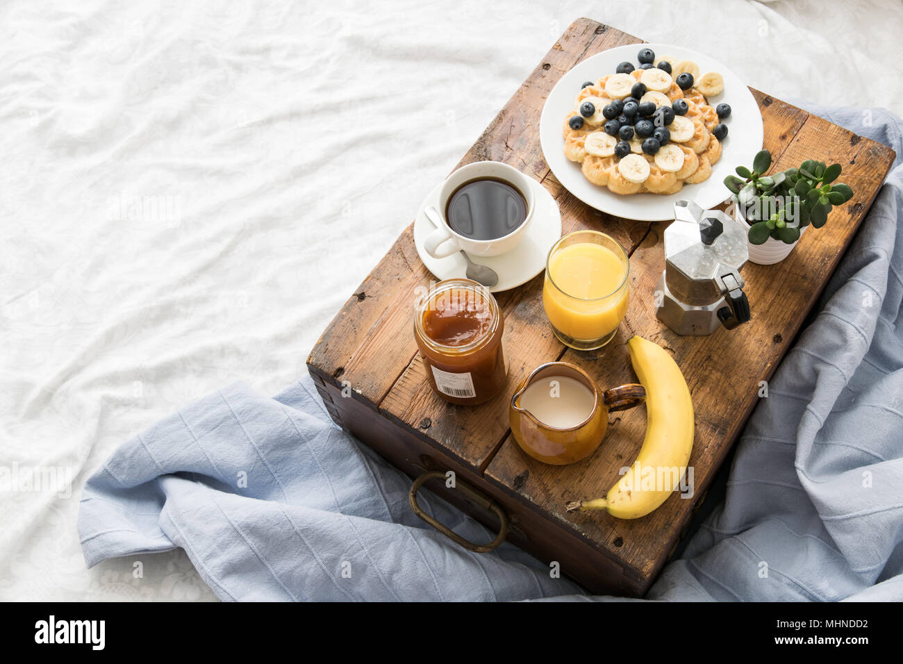 Gemütliches Frühstück Szene im Bett mit Waffeln auf einem sonnigen Wochenende Stockfoto