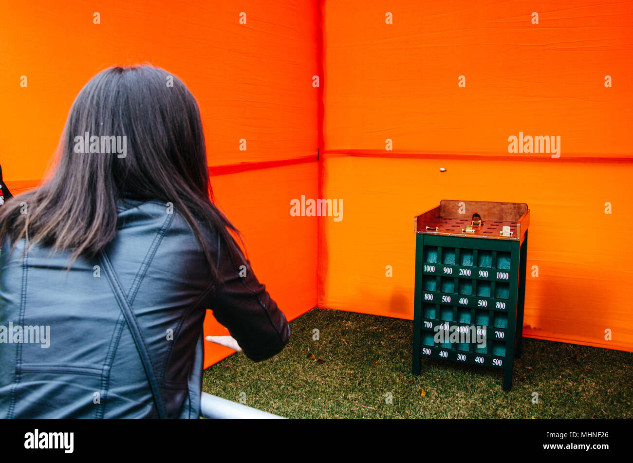 Mädchen spielen die Kröte Spiel, in dem es besteht aus Versuchen, Münzen in den Mund Ihres Kröte einzuführen Stockfoto