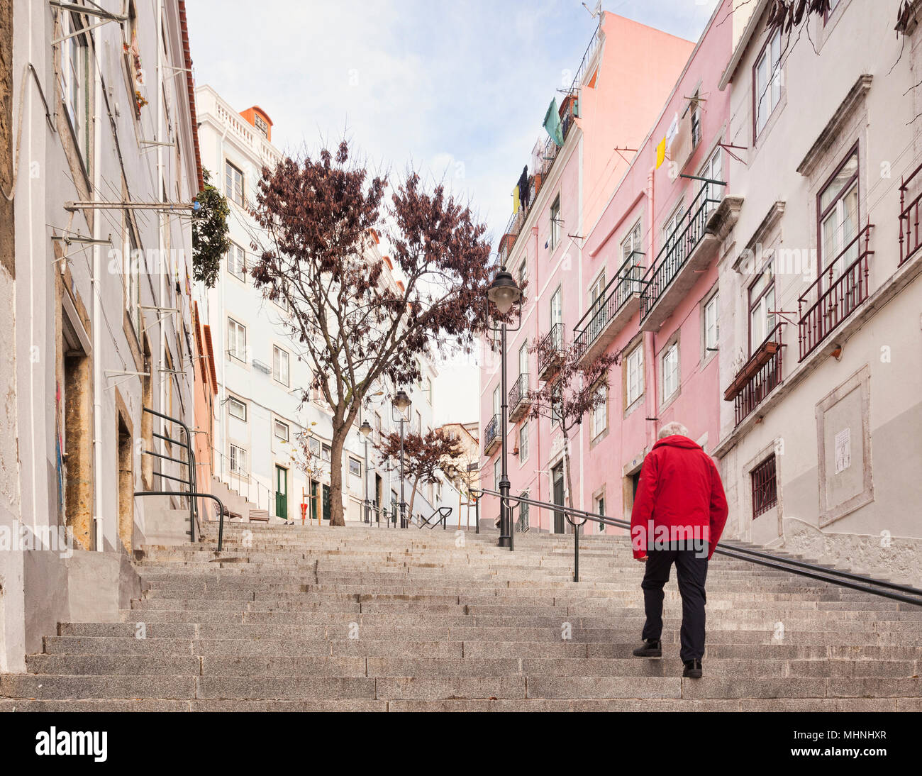 Mann in der roten Jacke, zu steile Stufen typisch für Lissabon, Portugal. Stockfoto