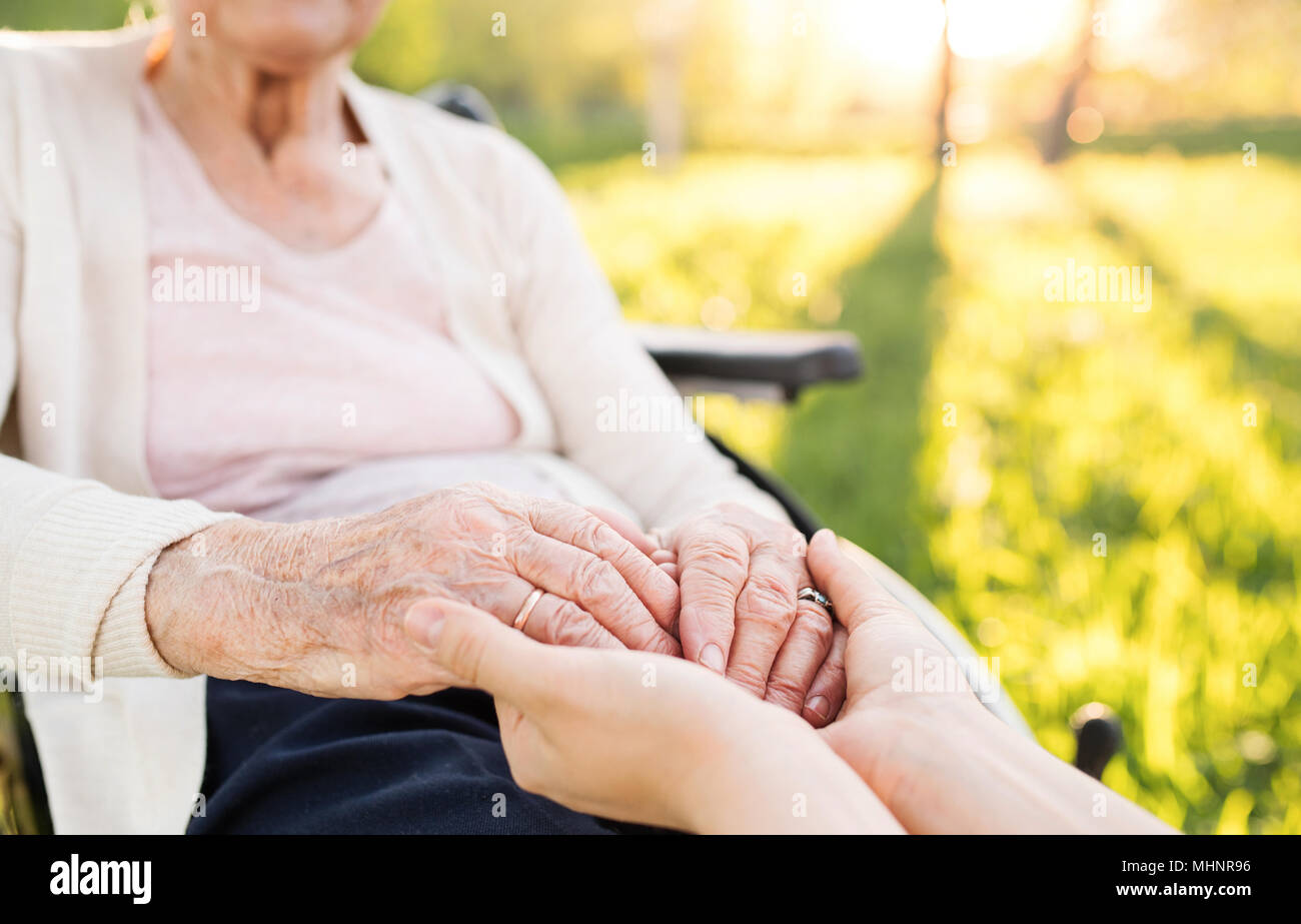 Ältere Großmutter im Rollstuhl mit Enkelin im Frühjahr die Natur. Stockfoto