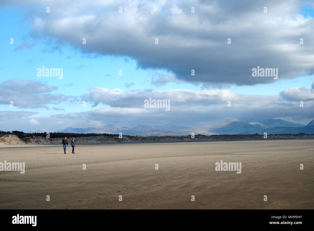 Ein paar wenige auf Ynys Llanddwyn Beach - rhosneigr Warren, Anglesey, Nordwales mit snowdonia im Hintergrund Stockfoto