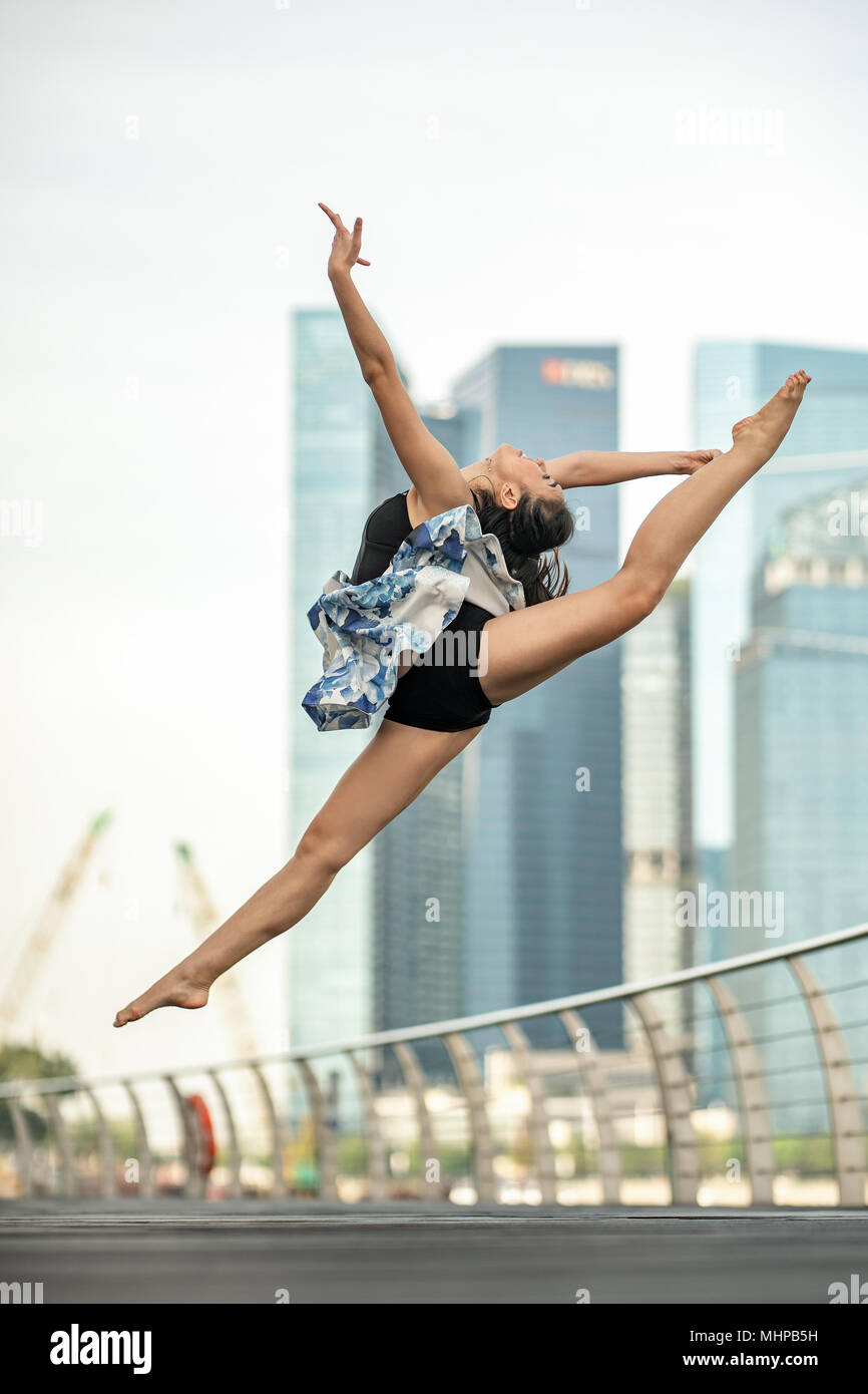 Tanz in der Luft... Schöne junge Tänzer posiert, Aqua-lounge perfekten Sprung, Hintergrund der Wolkenkratzer Stockfoto