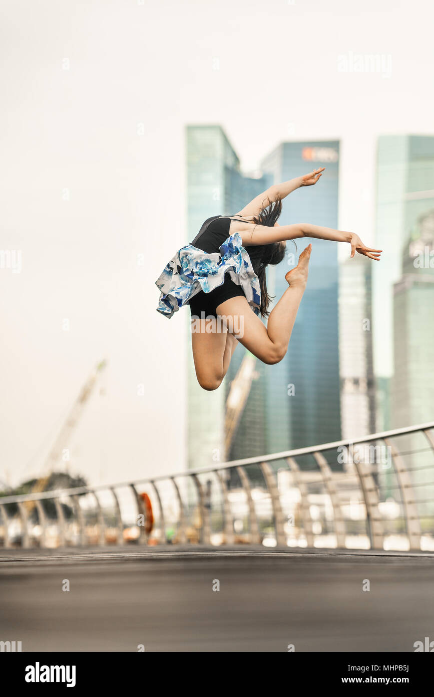 Tanz in der Luft... Schöne junge Tänzer posiert, Aqua-lounge perfekten Sprung, Hintergrund der Wolkenkratzer Stockfoto