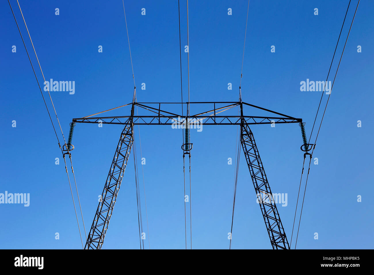 Stromleitungen und Pylon für hohe Spannung isoliert auf blauen Himmel. Stockfoto