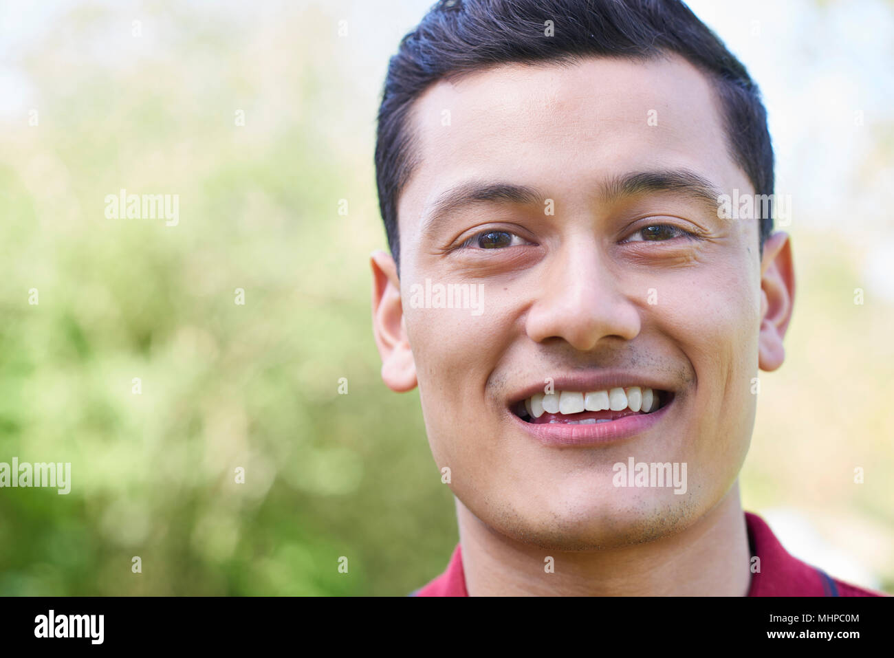 Im freien Kopf und Schultern Porträt von lächelnden jungen Mann Stockfoto