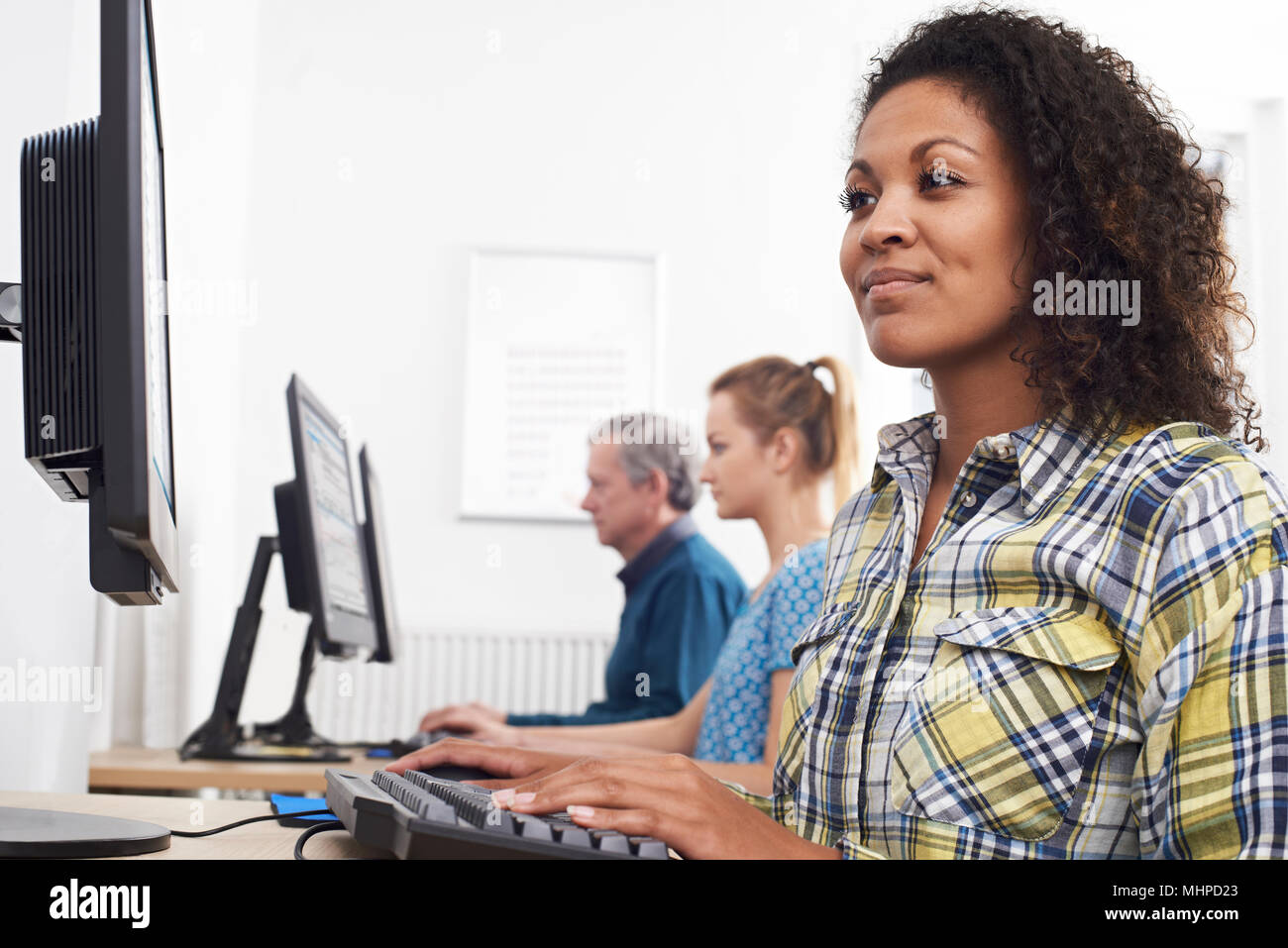 Junge Frau an Computer Klasse Stockfoto