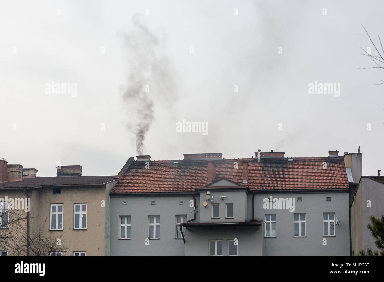 Oswiecim, Polen - Schwarzer Rauch aus dem Schornstein des Tenement House während Kohle - liebevolle Polen kämpft mit killer Smog. Die Luftverschmutzung. Stockfoto