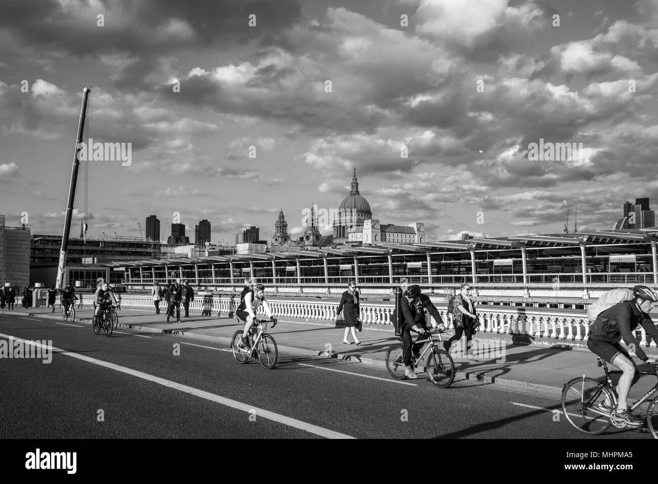Fußgänger und Radfahrer unterwegs - Wandern und Radfahren zu arbeiten - über Blackfriars Bridge, London mit St Paul's Kathedrale im Hintergrund. Stockfoto