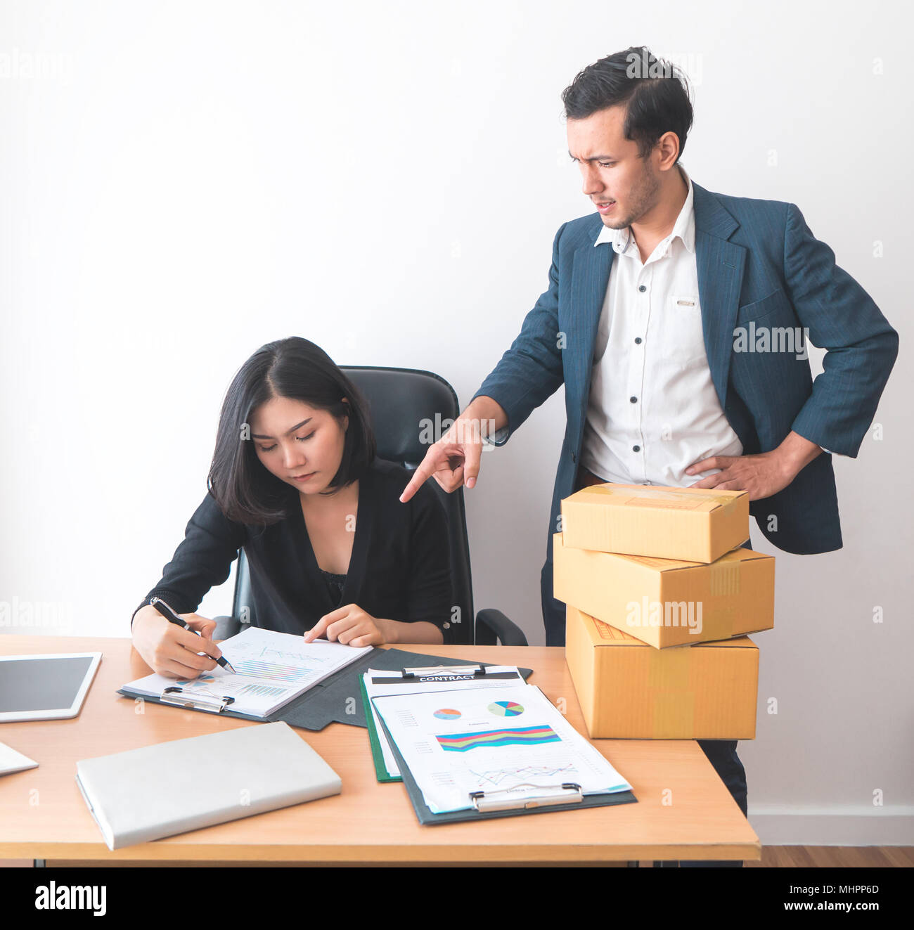 Weibliche Büroangestellte arbeitet unter dem Druck von Supervisor Stockfoto