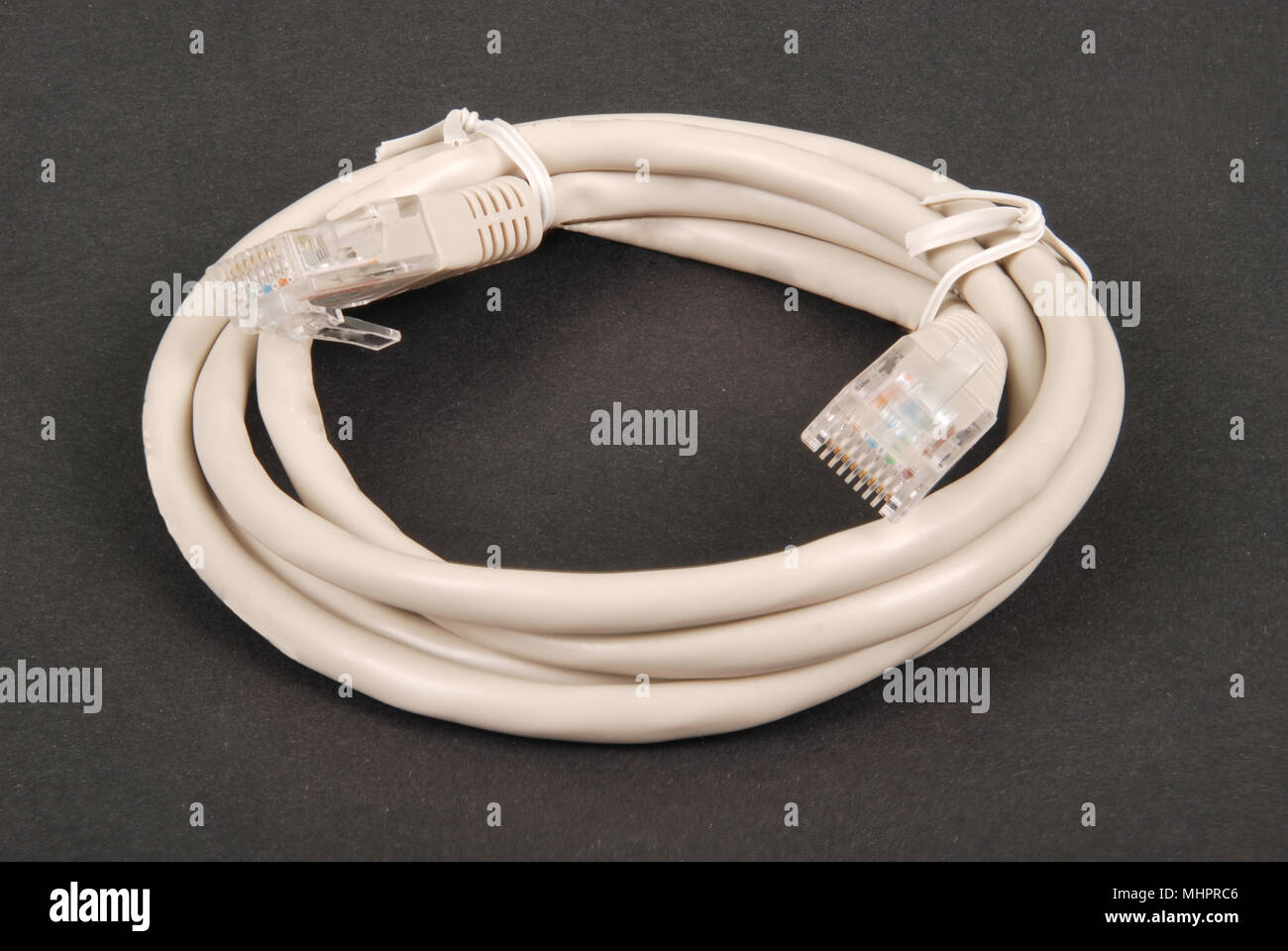 Patchkabel grau Netzwerkkabel mit RJ45-Stecker, auf einem schwarzen Hintergrund isoliert Stockfoto