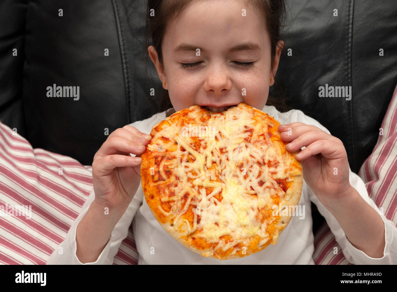 6-Jähriges Mädchen essen Pizza Stockfoto