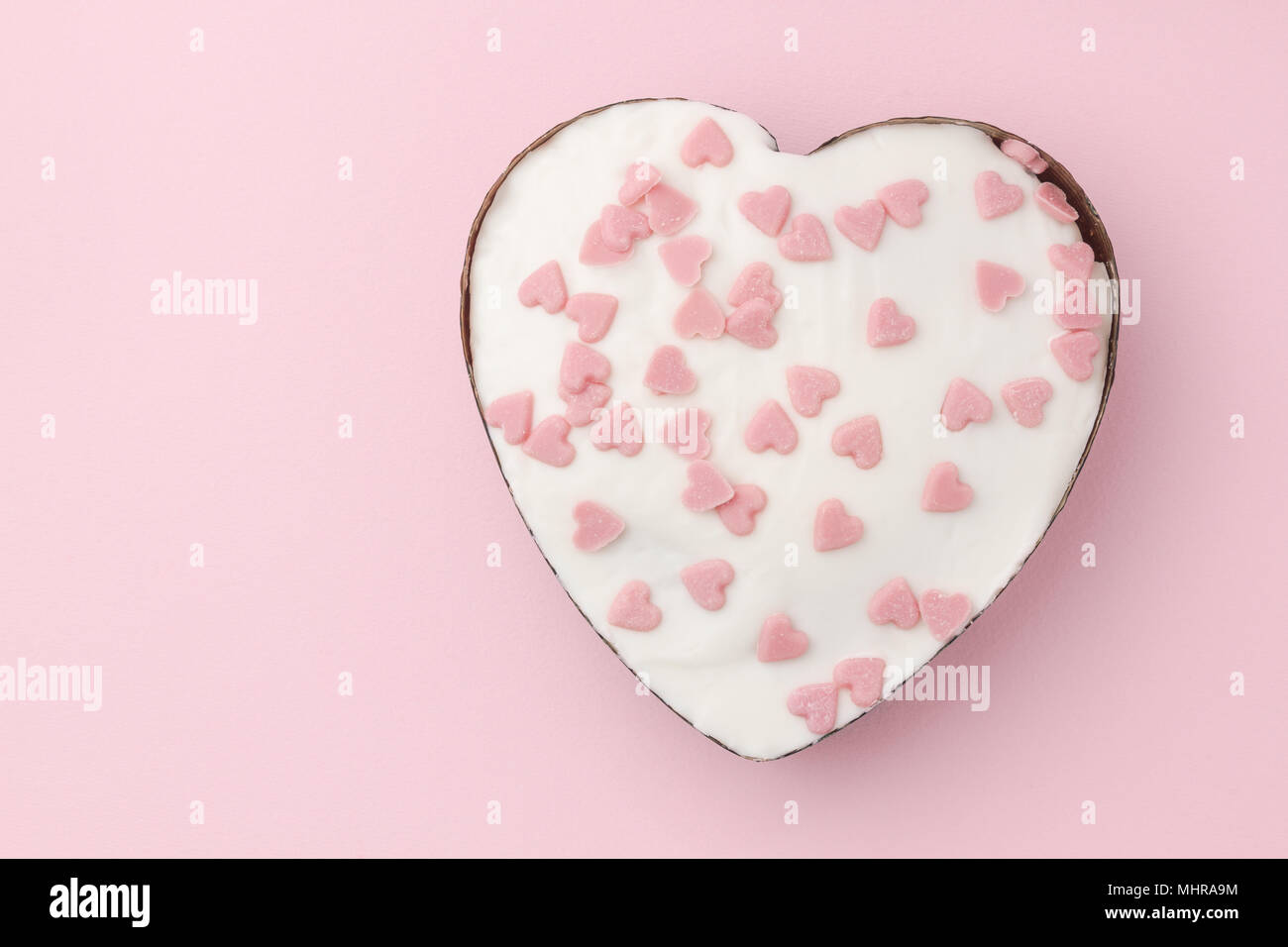 Weißen herzförmigen Muffin mit wenig Zucker Herzen Rosa auf rosa Hintergrund eingerichtet. Bild horizontal. Stockfoto