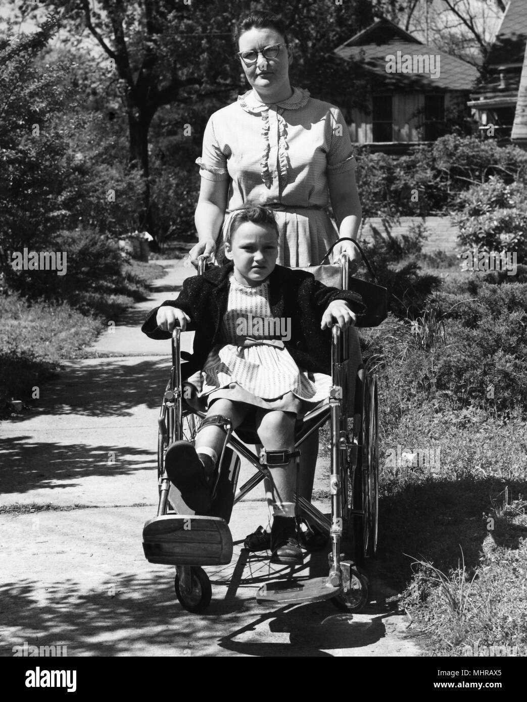 Junge Frau drückt ein Kind im Rollstuhl, das Bild zu ermutigen, Personen mit Polio Impfungen, 1968 zu erhalten. Mit freundlicher Seuchenkontrollzentren (CDC). () Stockfoto