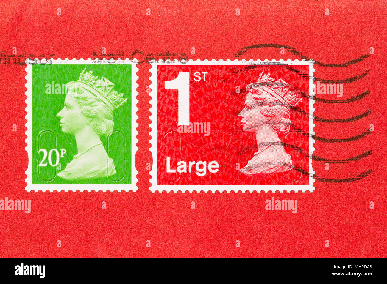 Nahaufnahme von einem Umschlag mit 2 Stempel, eine rote, eine grüne, von Königin Elisabeth II. Großbritannien Briefmarke auf rotem Papier. Stockfoto