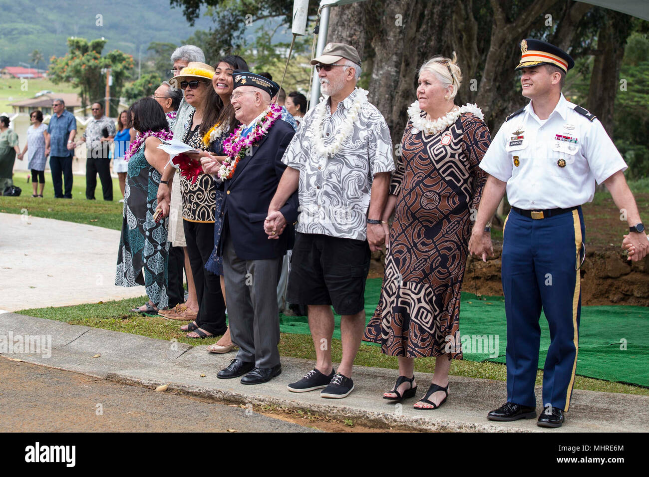 Teilnehmer singen und halten die Hände während einer Feierstunde im Hawaii Memorial Park, Kaneohe, Hawaii, März 17, 2018. Mehrere Organisationen einschließlich der Bundes-, Landes- und örtlichen Mitglieder dazu beigetragen, den Bau einer steinernen Denkmal zu Ehren der Gold Star Familien, die ihre Angehörigen verloren haben, während in den USA Militär dienen. Die Gold Star Familien Denkmal Stiftung von WWII-Ehrenmedaille war Empfänger Hershel "Woody" Williams im Jahr 2010 erstellt, um Familien, die das ultimative Opfer gemacht haben, erinnern. (U.S. Marine Corps Stockfoto