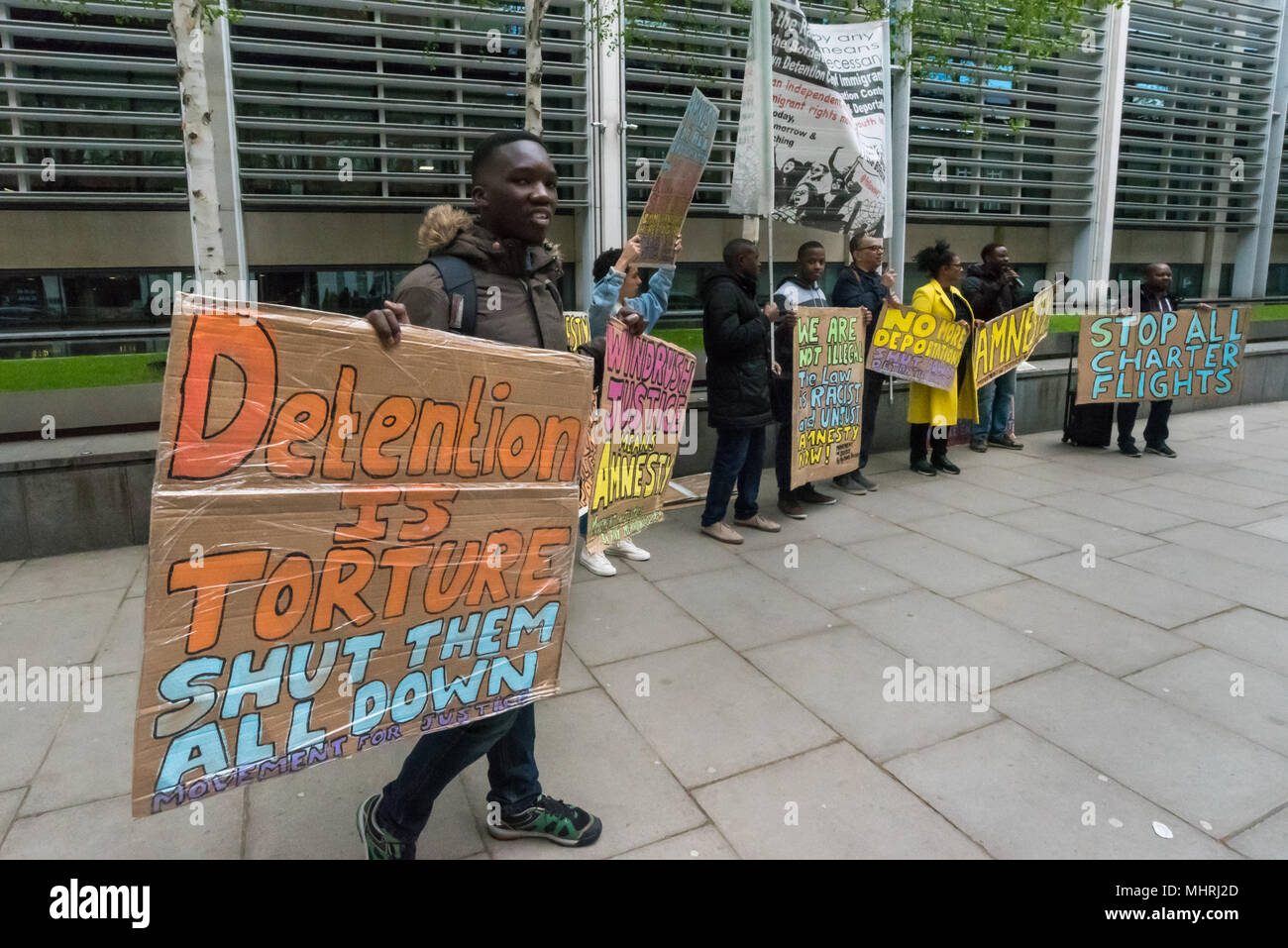 Mai 1, 2018, London, UK. 1. Mai 2018. Die Demonstranten halten Plakate und Banner im Home Office durch Bewegung für Gerechtigkeit, für ein Ende der Einwanderung Charterflüge. Der Protest wurde aufgerufen, das Home Office eine massenhafte Deportation nach Jamaika in der Mitte des Windrush Skandal einschließlich der Mitglieder der Windrush generation durchführen will. Der Protest im Home Office und später an der jamaikanischen Hohe Kommission für ein Ende dieser Massenabschiebungen, die zu einer Aufrundung von Vielen, die in diesem Land legal sind, aber deren Fälle werden noch durch das Home Office umstrittenen geführt haben. Stockfoto