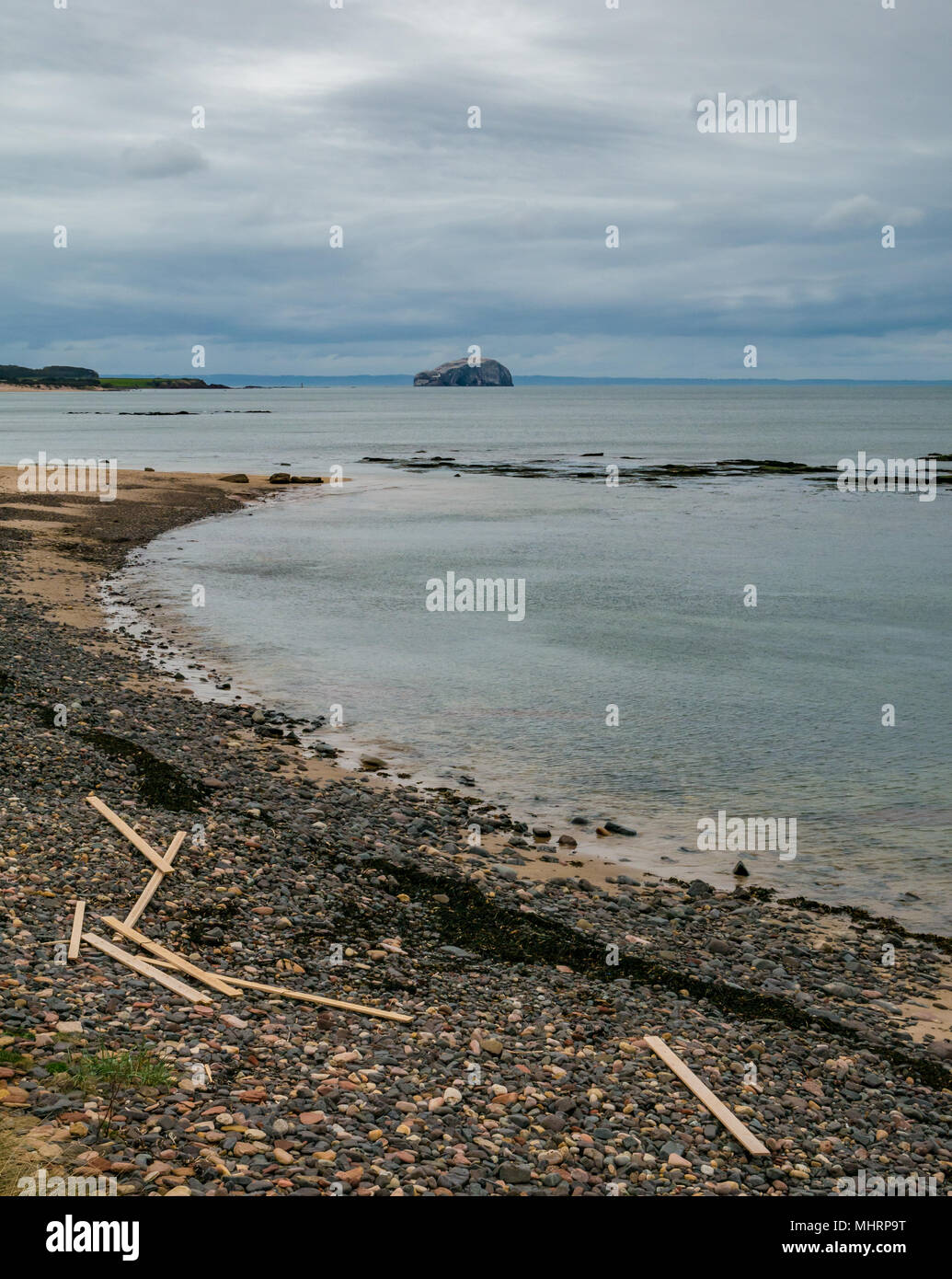 Ravensheugh Sands, East Lothian, Schottland, Vereinigtes Königreich, 2. Mai 2018. Niemand am Strand über den Firth von weiter in Richtung Bass Rock, Heimat der weltweit größten Northern gannet Kolonie. Planken von Holz liegen noch bis nach Verschütten von Frachter friesischen Dame, die das Holz Bundles bei strengem Wetter am 2. März während des Tieres aus dem Osten wetter Fall verloren gewaschen Stockfoto