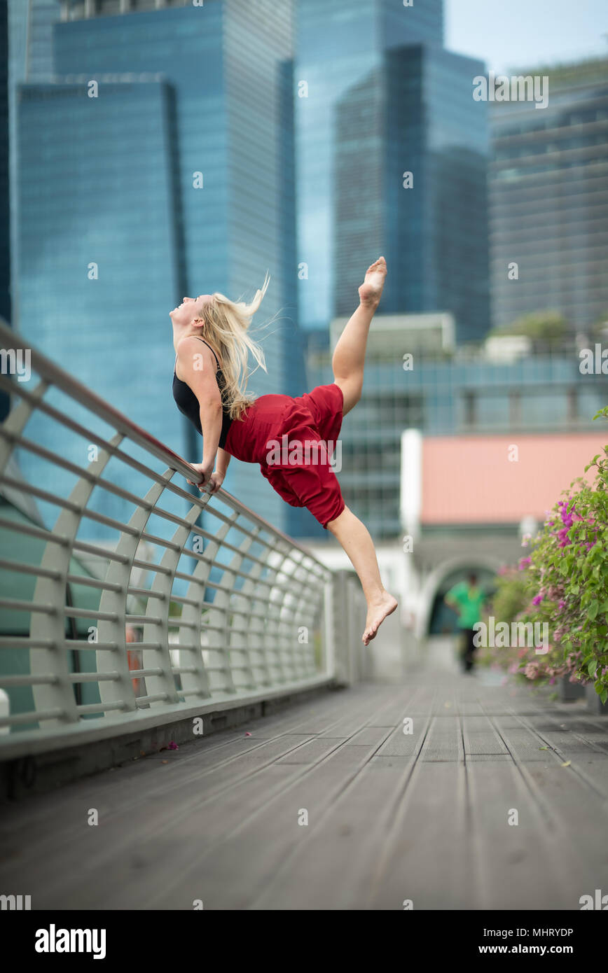 Schöne junge Mädchen tanzen auf einer Brücke Stockfoto