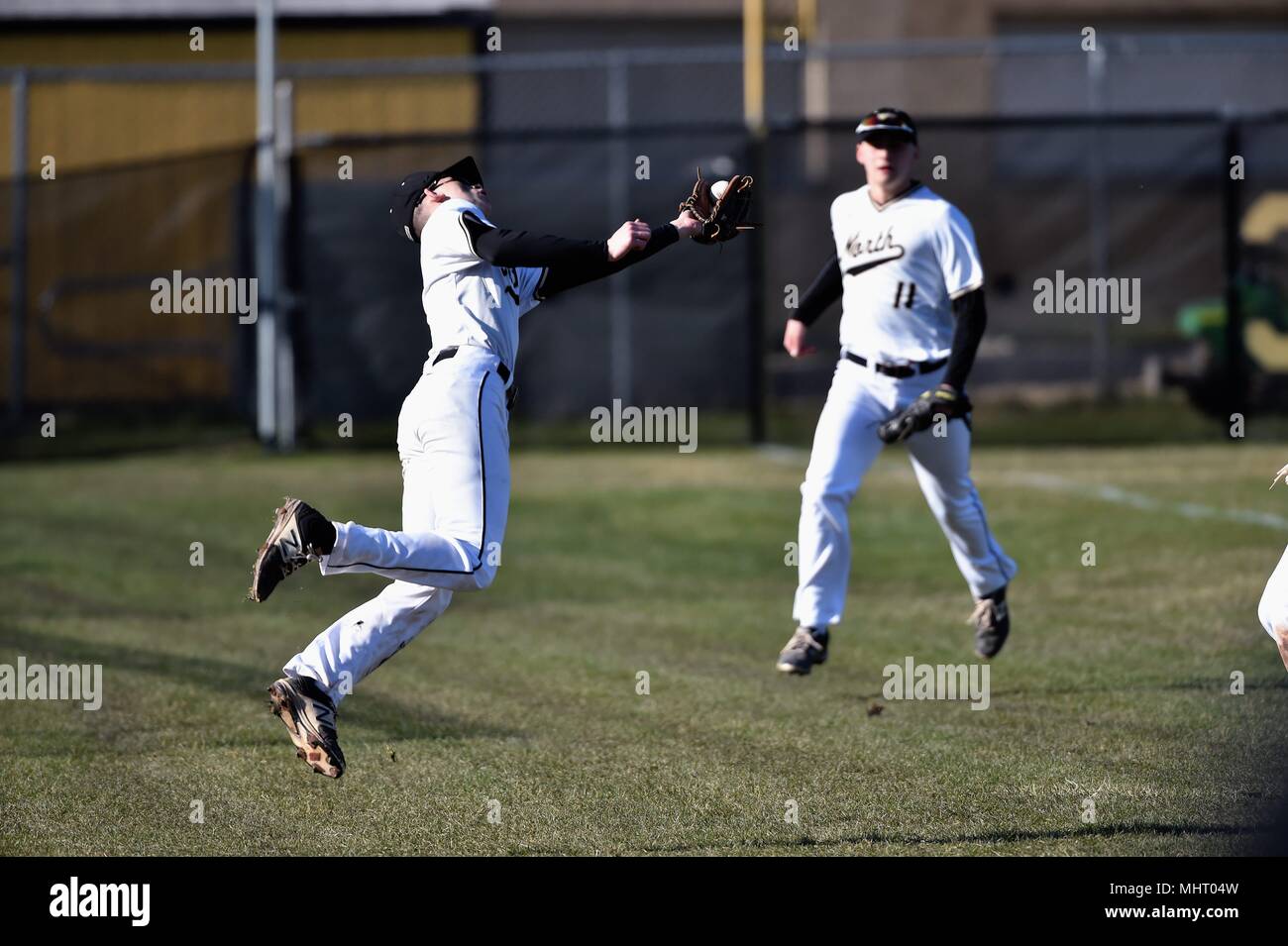 Dritter Basisspieler eine Tauchen versuchen, einen pop im outfield Gras hinter der dritten Base zu fangen. USA. Stockfoto