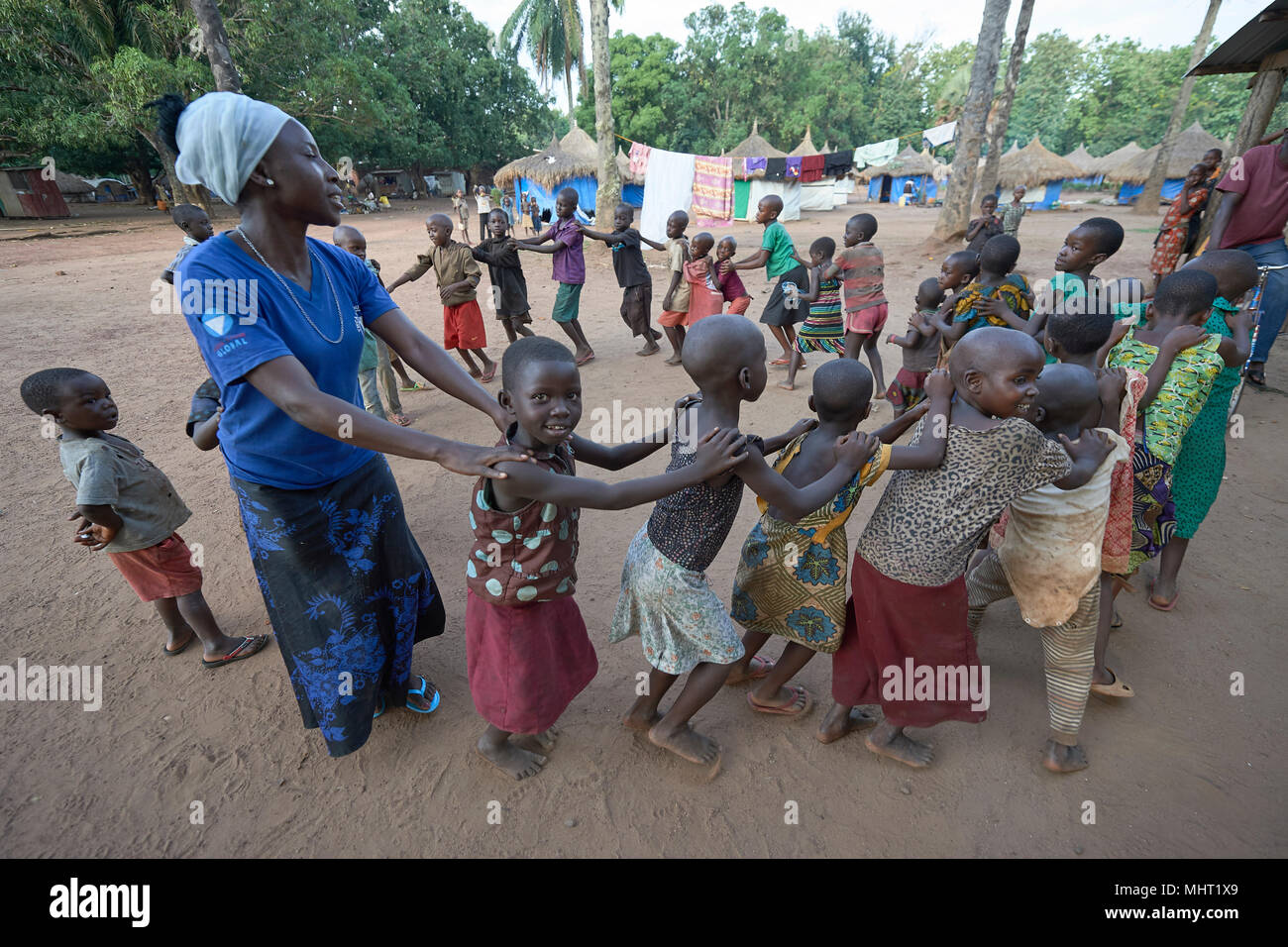 Ein Erzieher spielt mit Kindern, deren Familien durch Krieg vertrieben wurden und Zuflucht in einem Flüchtlingslager durch eine Kirche in Riimenze, South Sudan. Stockfoto