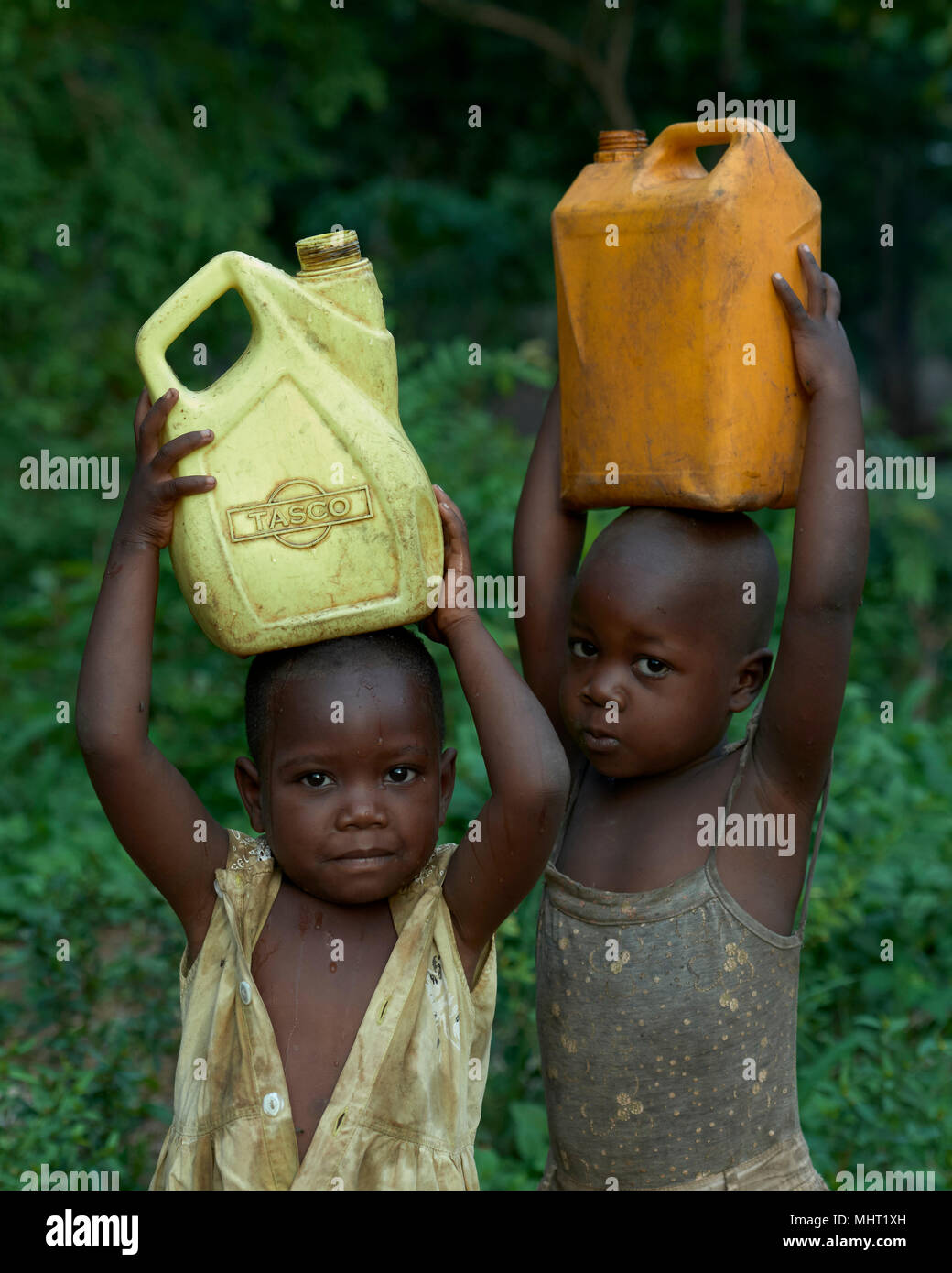 Kinder von Vertriebenen Wasser tragen in ein Lager für Binnenvertriebene, die um die katholische Kirche in Riimenze, Südsudan gebildet. Stockfoto