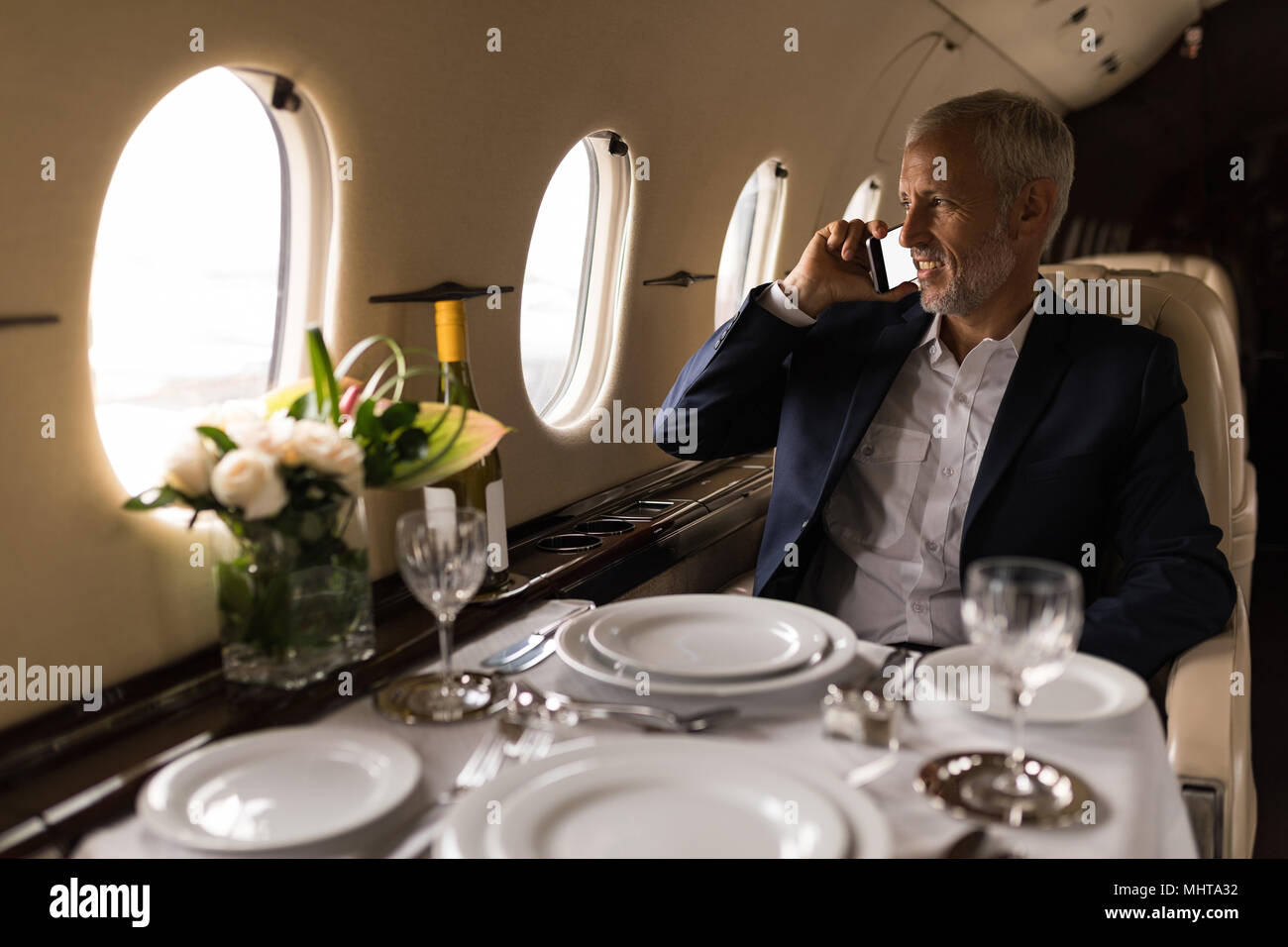 Unternehmer Gespräch am Handy in Private Jet Stockfoto