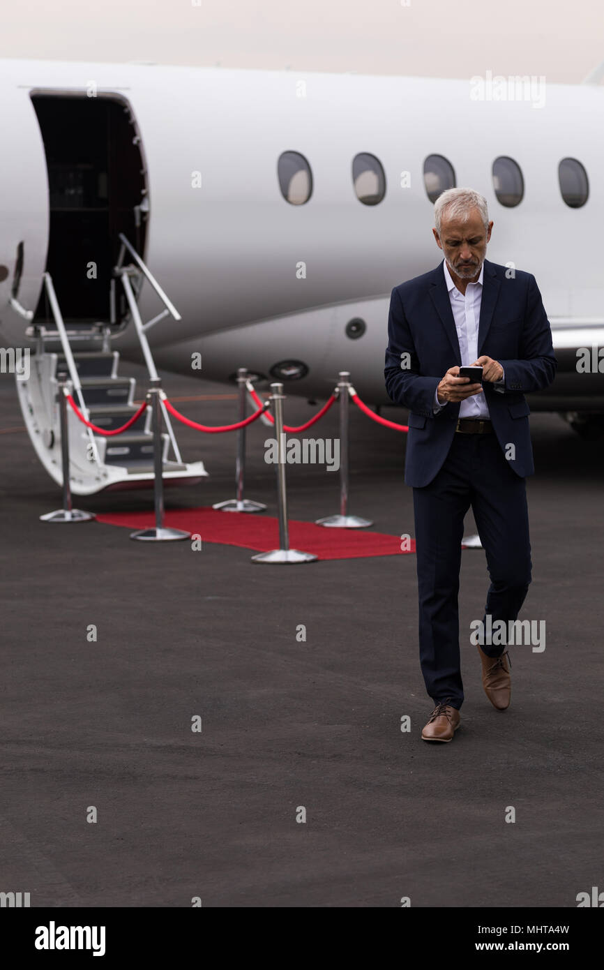 Mit Handy, während private jet Geschäftsmann Stockfoto