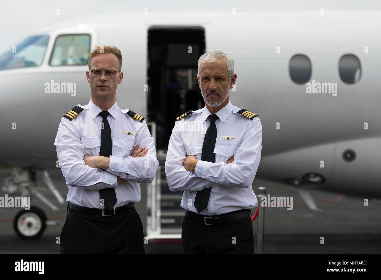Zwei männliche Piloten Stehen mit verschränkten Armen Stockfoto