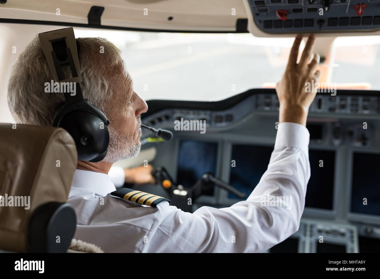 Männliche pilot Drücken der Taste im Cockpit Stockfoto