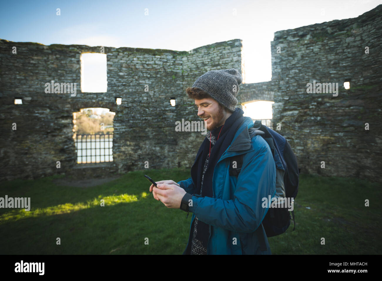Männliche Wanderer mit Handy in der Altstadt an der Landschaft ruinieren Stockfoto