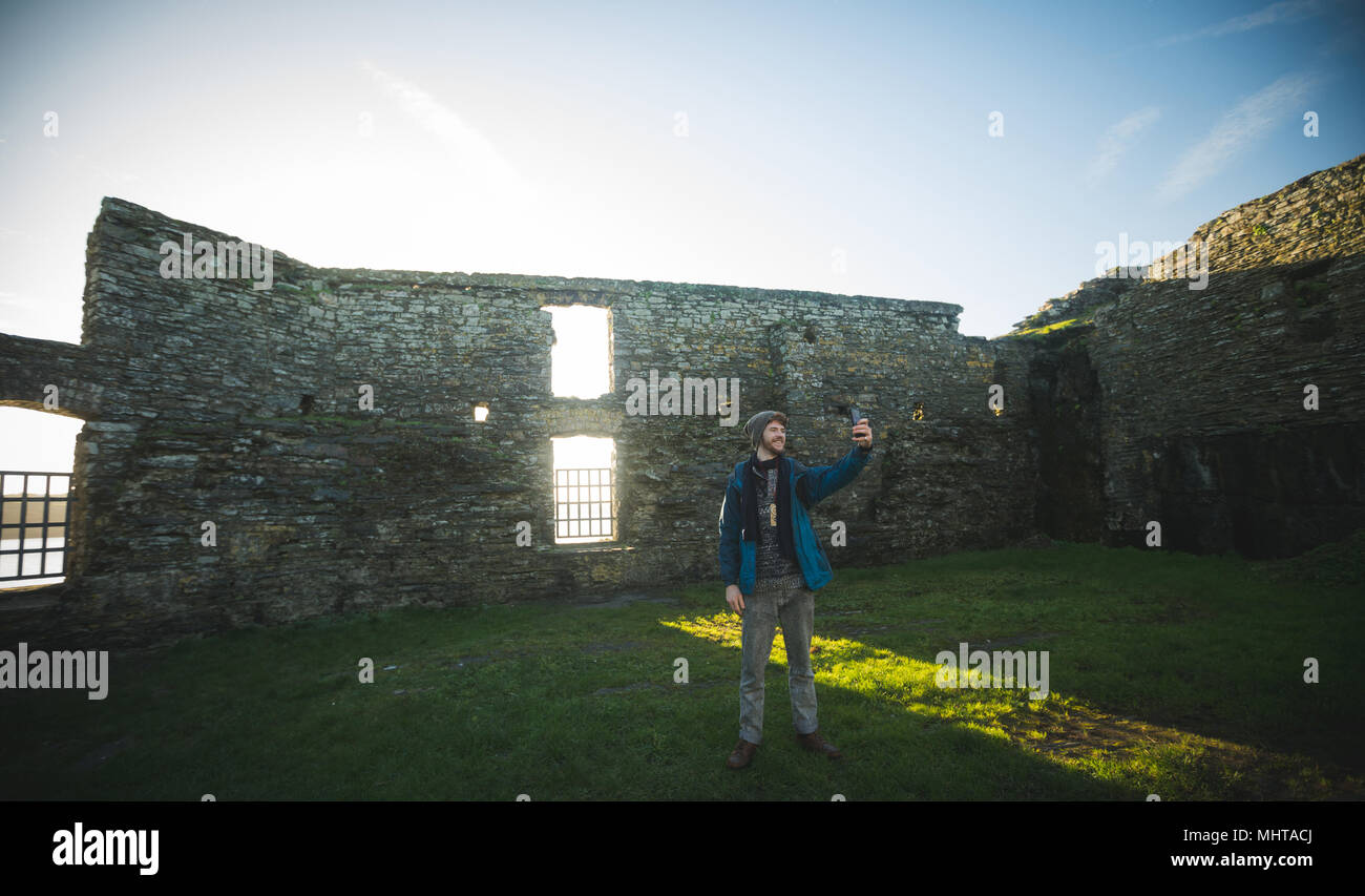 Männliche Wanderer unter selfie mit Handy in der alten Ruine Stockfoto