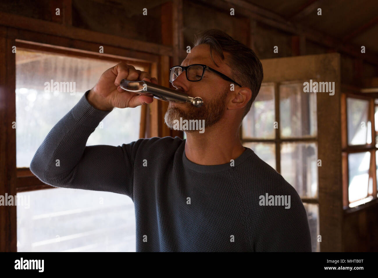 Mann trinken Whisky in Blockhaus Stockfoto